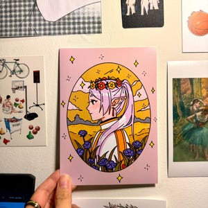 May include: A pink and yellow illustration of a female elf with long purple hair wearing a white and orange outfit. She is wearing a flower crown and standing in a field of flowers. The background is a sunset sky with clouds.