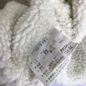 May include: White tag with black text. The tag has the text "AA-5181", "Size", "Chest", "Height", "34", "165-170", "M-L", "(NM-T)", "Manufacturer", "株式会社 デサワー", "Made in Japan", "134-5K".