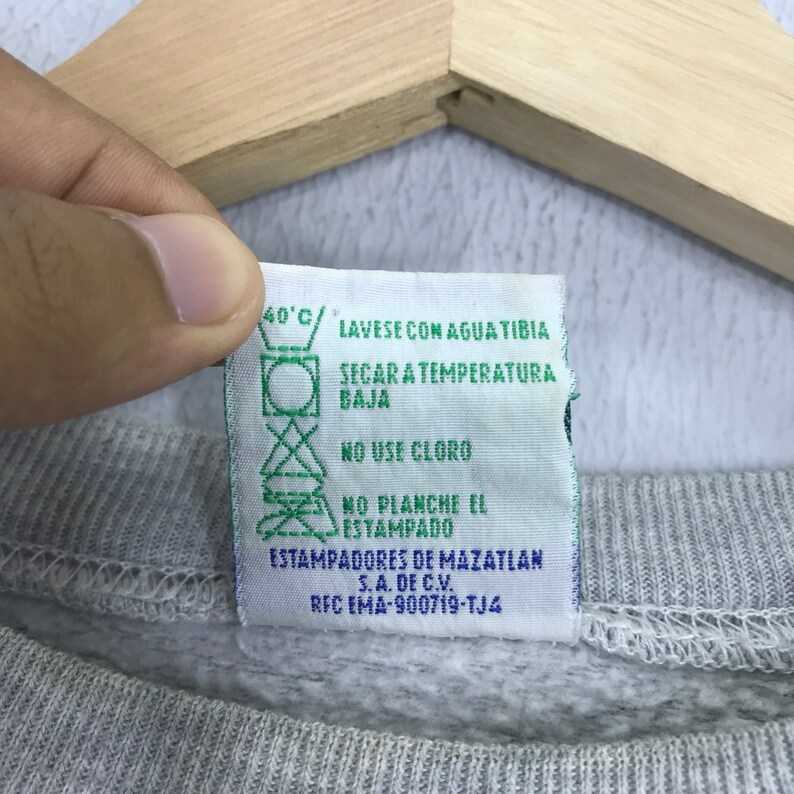 May include: White care label with green text and symbols. The text reads "40&deg;C/ LAVESE CON AGUA TIBIA SECAR A TEMPERATURA BAJA NO USE CLORO NO PLANCHE EL ESTAMPADO ESTAMPADORES DE MAZATLAN S.A. DE C.V. RFC EMA-900719-TJ4"