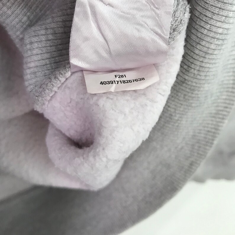 May include: A white tag with the text "F281 403917118267638" on a gray sweatshirt.