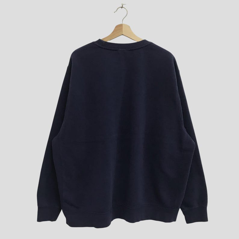 May include: A dark blue long-sleeved sweatshirt with a crew neck.