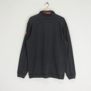 Peut inclure: Sweat-shirt &agrave; manches longues noir avec un logo rouge et blanc sur la manche gauche et "49ERS" en rouge &agrave; l'arri&egrave;re du col.