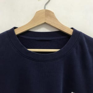 May include: A navy blue sweatshirt with a crew neck.