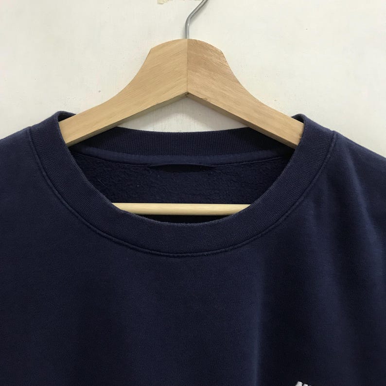 May include: A navy blue sweatshirt with a crew neck.