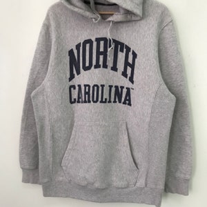 May include: Gray hooded sweatshirt with a navy blue "NORTH CAROLINA" logo printed on the front.