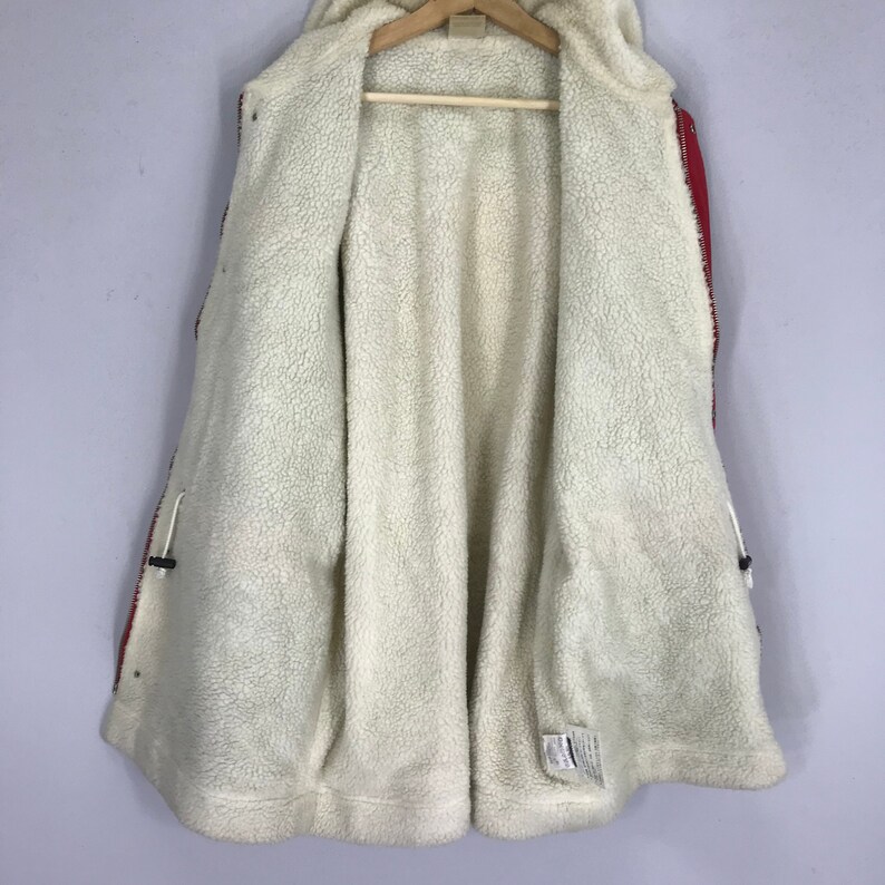 May include: Red and black hooded jacket with a white fleece lining. The jacket has a zipper closure and two pockets.