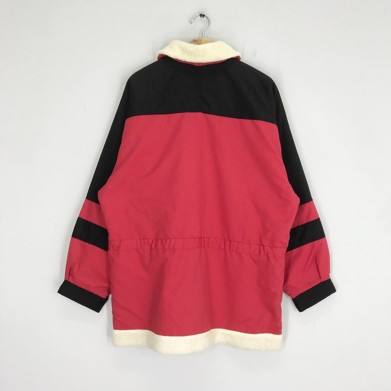 May include: A red and black jacket with a white fleece lining. The jacket has a zipper closure and a drawstring waist.