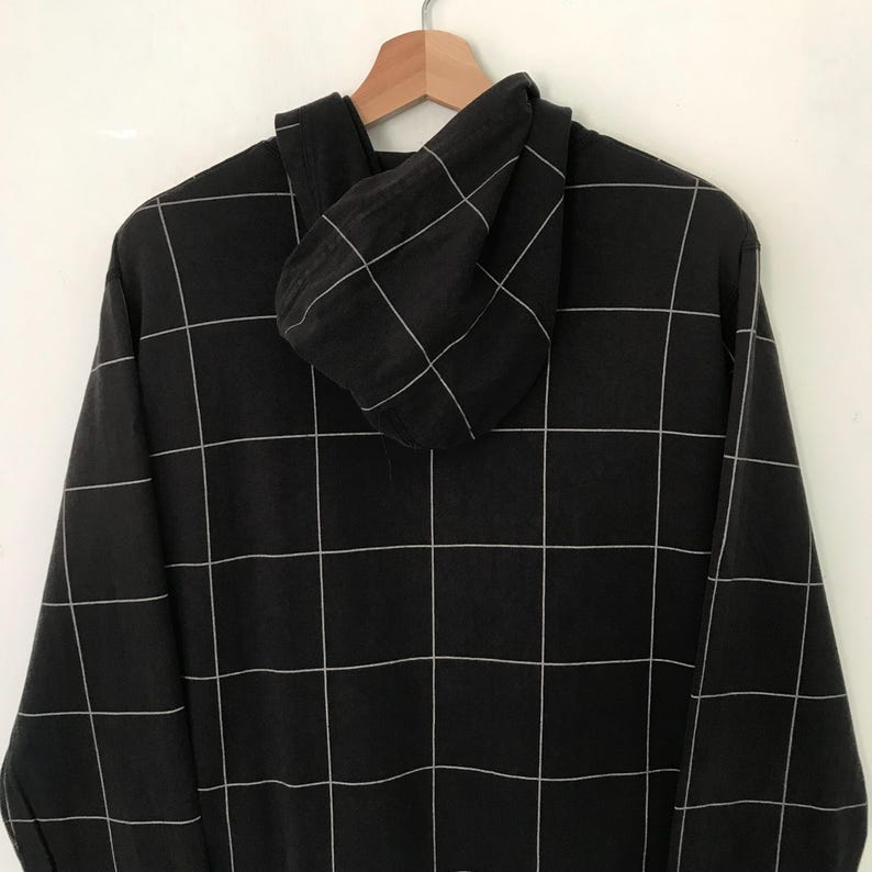 May include: Black hooded sweatshirt with a white grid pattern.