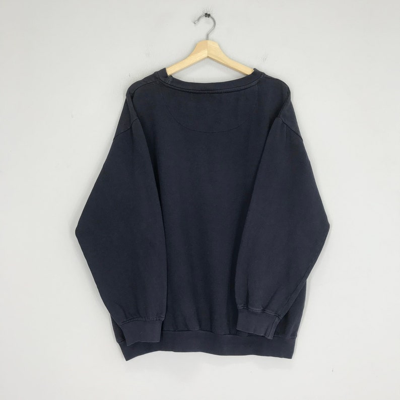 Puede incluir: Una sudadera de color azul marino oscuro con mangas largas y cuello redondo.