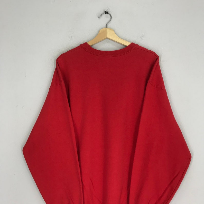 May include: A solid red sweatshirt with long sleeves and a crew neck.
