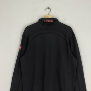 Peut inclure: Sweat-shirt &agrave; fermeture &eacute;clair noir &agrave; manches longues avec le mot "49ers" en rouge sur le col et un logo rouge et blanc sur la manche gauche.