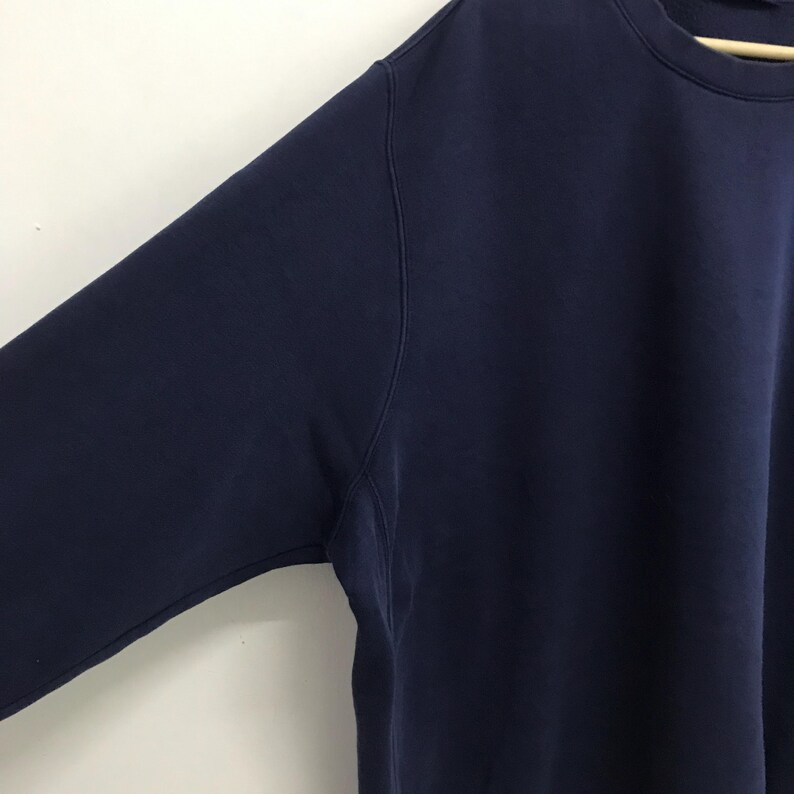 May include: A navy blue long-sleeved sweatshirt with a crew neck.