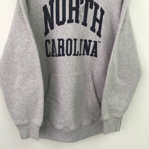 May include: Gray hooded sweatshirt with a navy blue "NORTH CAROLINA" logo on the front.