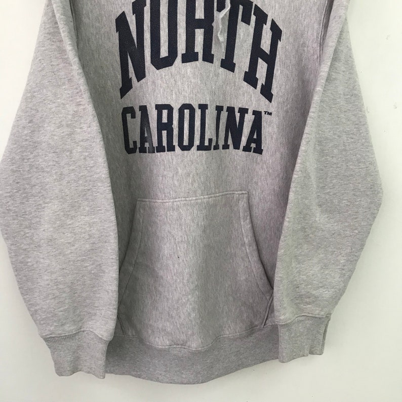 May include: Gray hooded sweatshirt with a navy blue "NORTH CAROLINA" logo on the front.