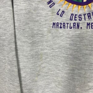 May include: Gray sweatshirt with a purple and yellow embroidered design that says "No Lo Destruyan Mazatlan, Mexico".