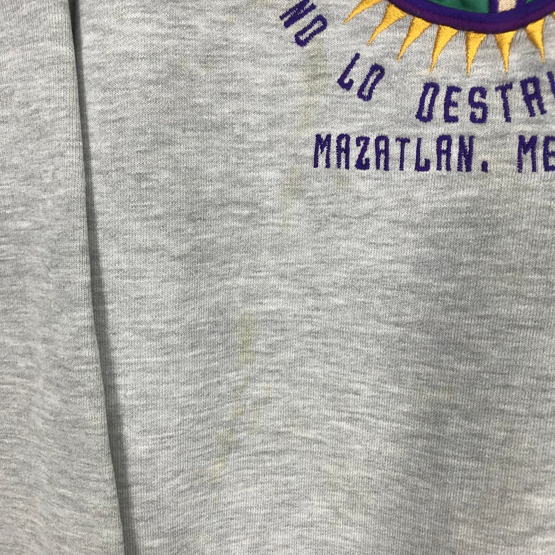 May include: Gray sweatshirt with a purple and yellow embroidered design that says "No Lo Destruyan Mazatlan, Mexico".