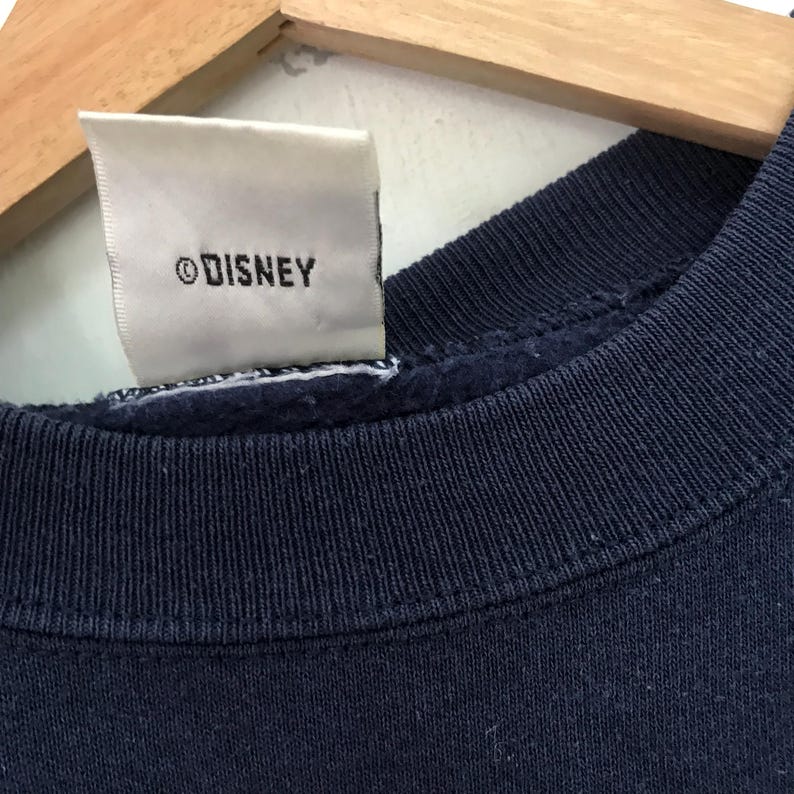 May include: A navy blue sweatshirt with a white tag that says "&copy;DISNEY".