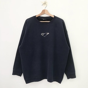 Puede incluir: Una sudadera azul oscuro con un logotipo plateado en la parte delantera. El logotipo es una letra "C" estilizada con una línea diagonal que la atraviesa.