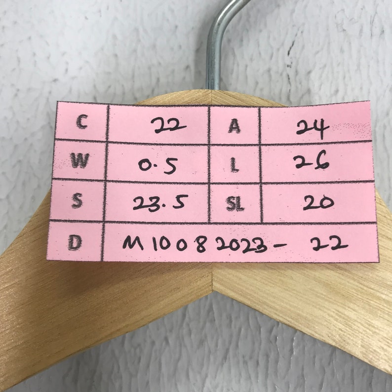 May include: A pink sticky note with a grid pattern and handwritten measurements in black ink. The note reads: "C 22 A 24 W 0.5 L 26 S 23.5 SL 20 D M1008 2023-22"