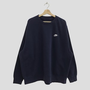 May include: A navy blue sweatshirt with a white Nike logo on the front.