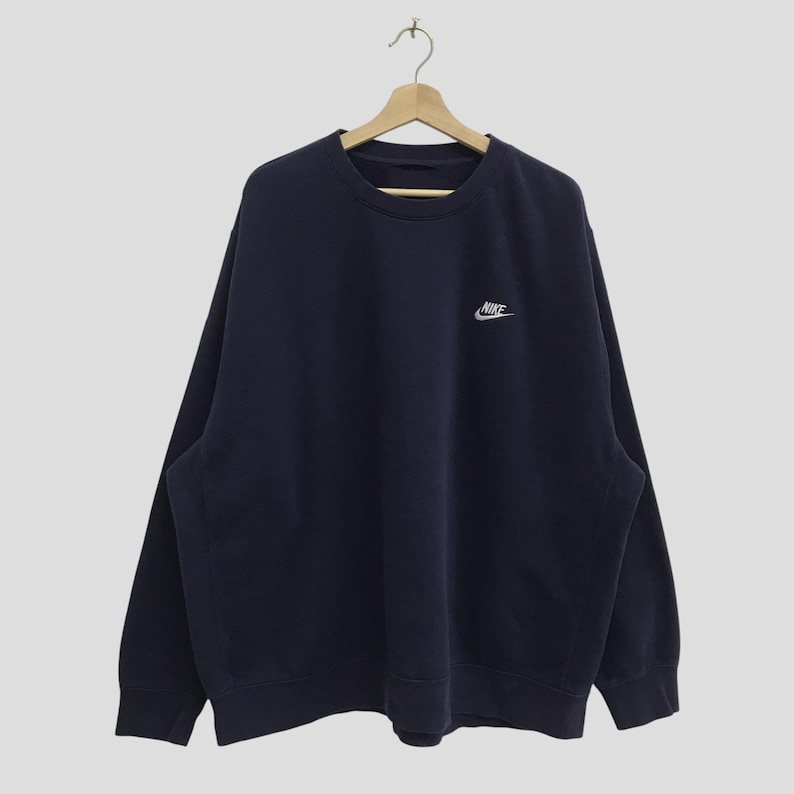 May include: A navy blue sweatshirt with a white Nike logo on the front.