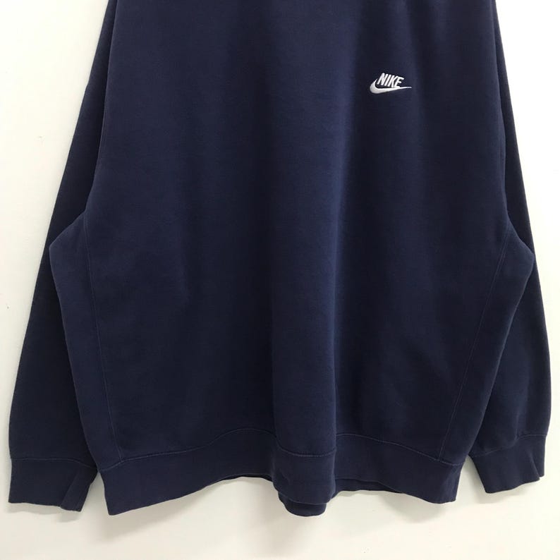 May include: A navy blue sweatshirt with a white Nike logo on the front.