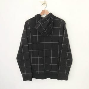 May include: Black hooded sweatshirt with a white grid pattern.
