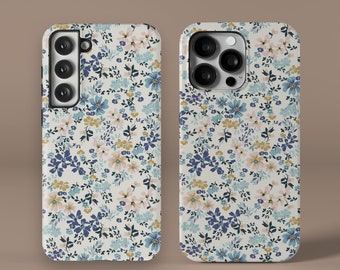 May include: Two phone cases featuring a floral design. The cases are white with blue, pink, and yellow flowers. The cases have a cut-out for the camera lens.