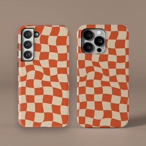 May include: Two phone cases with a wavy checkered pattern in orange and cream. The cases are designed to fit a smartphone with a camera bump.