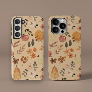 May include: Two phone cases with a fall-themed design. The cases are beige with a pattern of pumpkins, pears, leaves, and flowers in shades of orange, brown, and yellow.