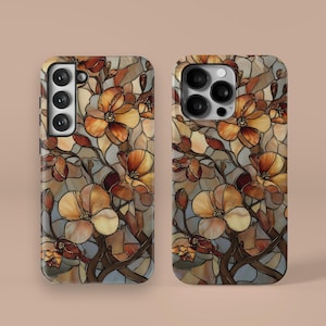 Può includere: Due custodie per telefono con un design floreale a vetrata. Il design presenta fiori beige, marroni e arancioni con steli e foglie marrone scuro su uno sfondo blu e grigio. Le custodie sono per diversi modelli di telefono.