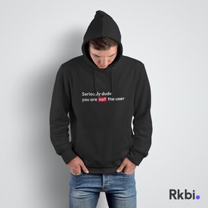 Könnte beinhalten: Schwarzer Kapuzenpullover mit dem Text "Seriously dude you are not the user" in Weiß, wobei das Wort "not" rot hervorgehoben ist.