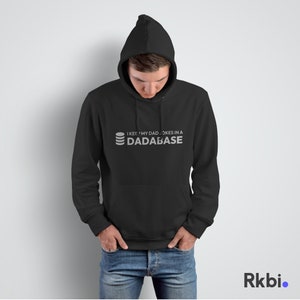 Op de afbeelding: Een zwarte hoodie met een witte afbeelding die "I keep my dad jokes in a dadabase" zegt.