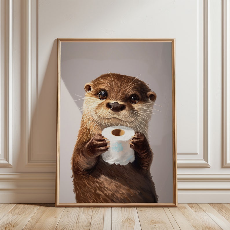 May include: A framed wall art print featuring a brown otter with dark eyes and whiskers holding a white roll of toilet paper. The otter has detailed fur texture and is centered in the frame against a solid light gray background.