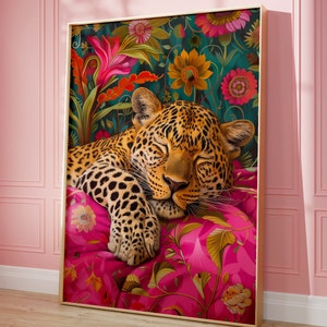 May include: A sleeping leopard with brown and black spots, lying on a pink and green floral patterned cushion. The leopard is surrounded by a lush green and floral background.