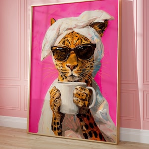 Op de afbeelding: Een schilderij van een luipaard met een witte handdoek op zijn kop en een zonnebril, die een witte mok vasthoudt. De achtergrond is fel roze.
