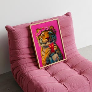 May include: A framed art print featuring a tiger with a pink flower crown on its head, holding a red drink with a straw against a vibrant magenta background. The tiger has its eyes closed and is depicted in a painterly style with orange and black stripes.