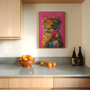 May include: A framed wall art print featuring a tiger wearing a pink flower crown and holding a red drink with a straw against a vibrant pink background. The tiger has orange and black fur and is depicted with its eyes closed in a relaxed expression.