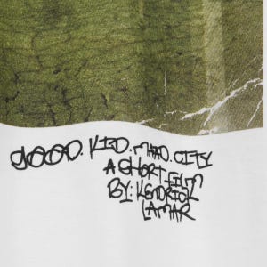 May include: White fabric featuring a green and white abstract pattern. The text "good kid m.A.A.d city A SHORT FILM BY: KENDRICK LAMAR" is written in black, handwritten-style lettering.