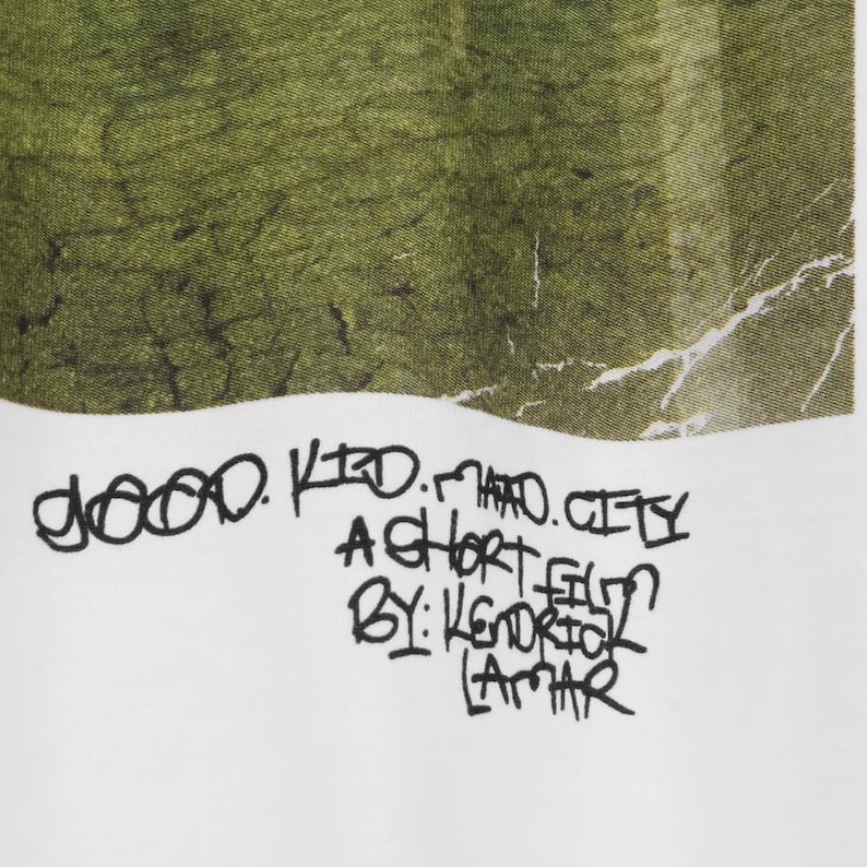 May include: White fabric featuring a green and white abstract pattern. The text "good kid m.A.A.d city A SHORT FILM BY: KENDRICK LAMAR" is written in black, handwritten-style lettering.