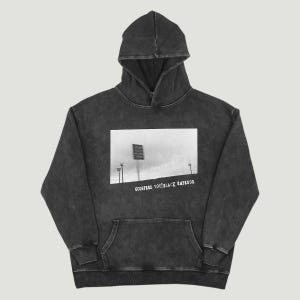 Può includere: Una felpa con cappuccio color grigio antracite lavato con un motivo grafico rettangolare in bianco e nero raffigurante una torre faro da stadio sotto un cielo nuvoloso. Il testo GODSPEED YOU! BLACK EMPEROR è stampato in bianco sotto la grafica.