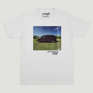 May include: White t-shirt with a square image of a dark minivan parked on grass under a blue sky. The image has a vintage, slightly distressed appearance. Text at the bottom reads "DODO PRO-TWO CITY AGAINST BY HERSELF".