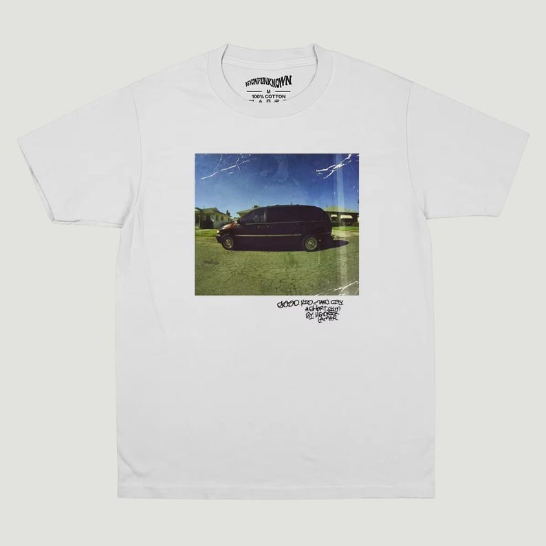 May include: White t-shirt with a square image of a dark minivan parked on grass under a blue sky. The image has a vintage, slightly distressed appearance. Text at the bottom reads "DODO PRO-TWO CITY AGAINST BY HERSELF".