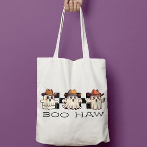 May include: White tote bag featuring three cartoon ghosts wearing cowboy hats and the text "BOO HAW" printed on the front.