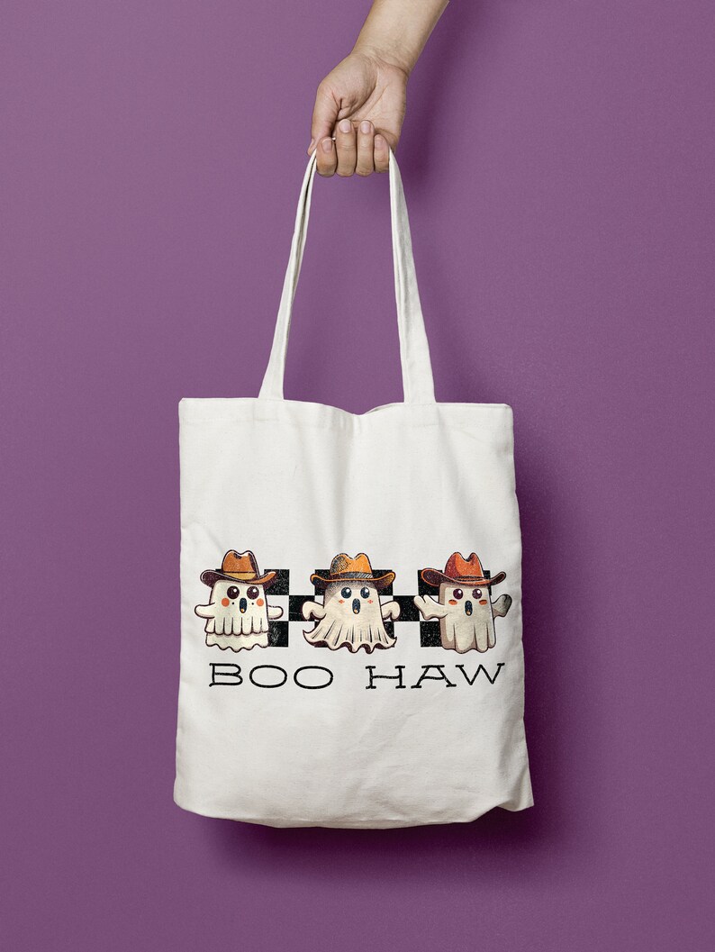 May include: White tote bag featuring three cartoon ghosts wearing cowboy hats and the text "BOO HAW" printed on the front.