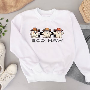 May include: White sweatshirt featuring a design of three ghosts wearing cowboy hats and the text "BOO HAW" on a black and white chequered background.