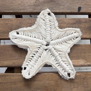 May include: A white crocheted starfish with a fringed edge.