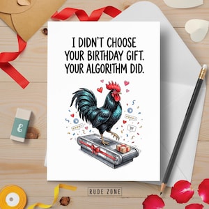 May include: A white greeting card featuring a black rooster standing on a conveyor belt with a gift box. The text reads: I DIDN'T CHOOSE YOUR BIRTHDAY GIFT. YOUR ALGORITHM DID. The design includes small red hearts, star ratings, and shopping icons.