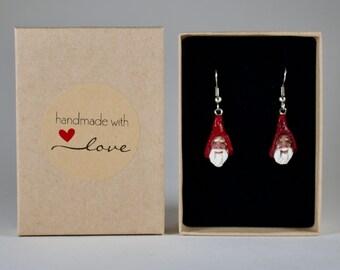 May include: A pair of red and white Santa Claus earrings in a small black box with a brown cardboard box that says "handmade with love" on a sticker.
