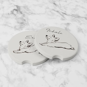 May include: Two light gray car coasters with a black line drawing of a corgi dog. One coaster says "Exhale" and the other says "Inhale" in black script. The coasters have a curved notch for easy removal.